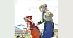 Manoeuvre roving stilt performers in costume at an outdoor event